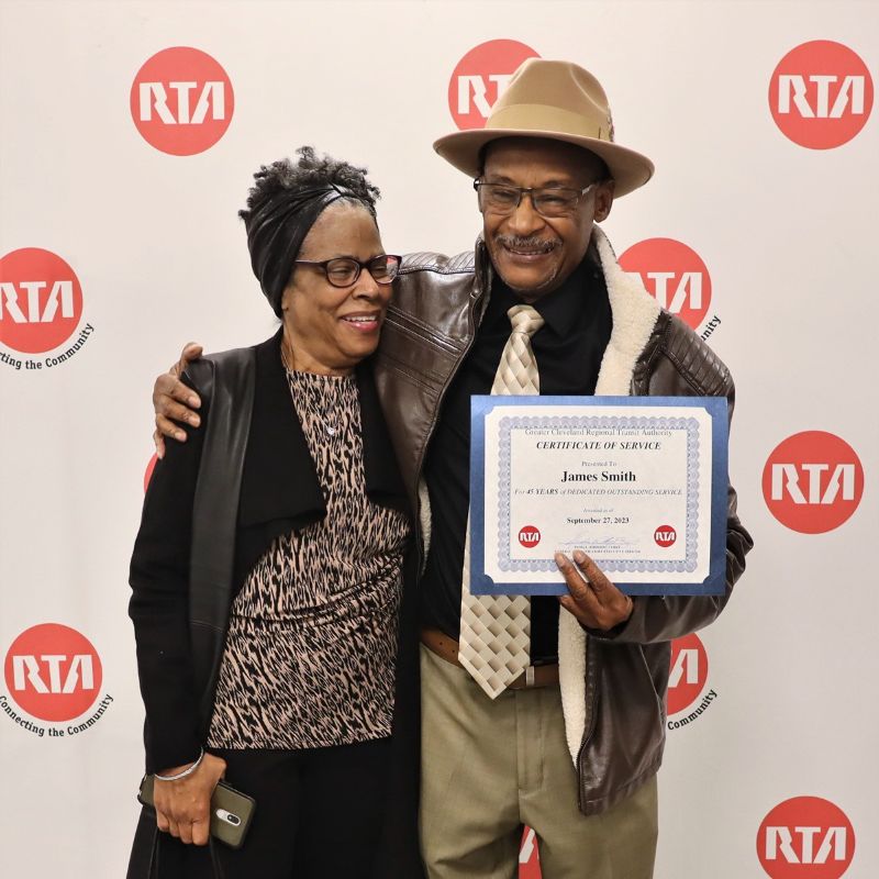 A smiling man and woman holding a certificate of service