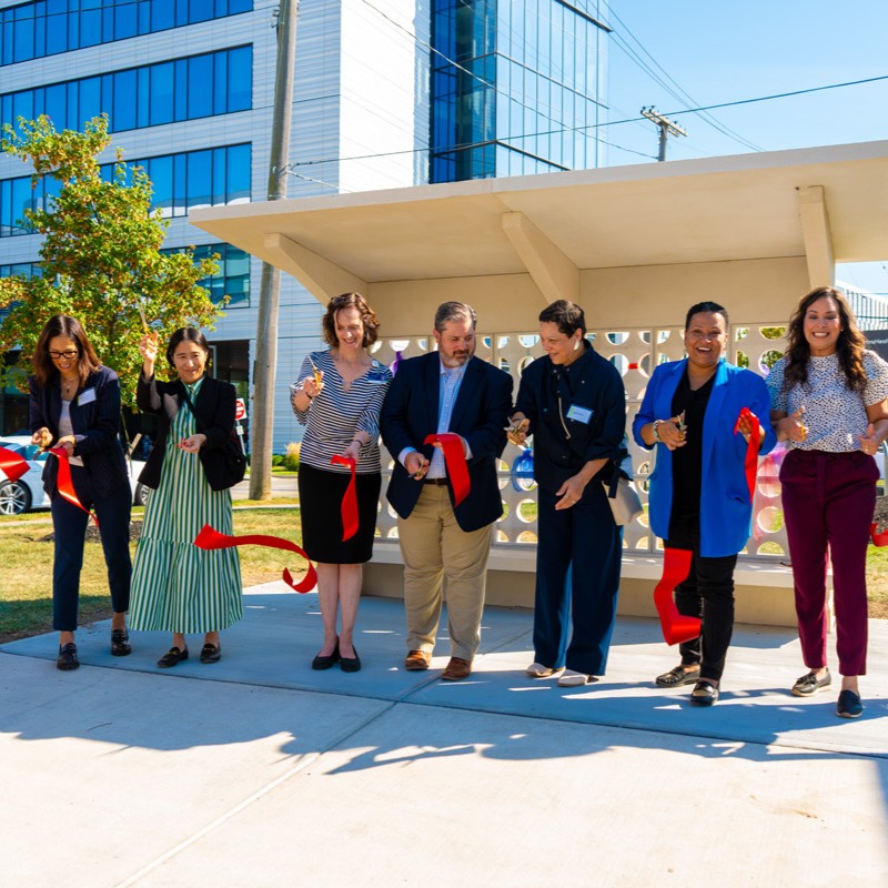 A group symbolically cutting a red ribbon